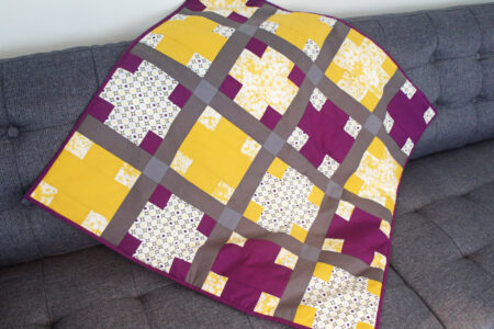 Lilla og gult patchwork babytæppe med krydser