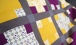 Lilla og gult patchwork babytæppe med krydser
