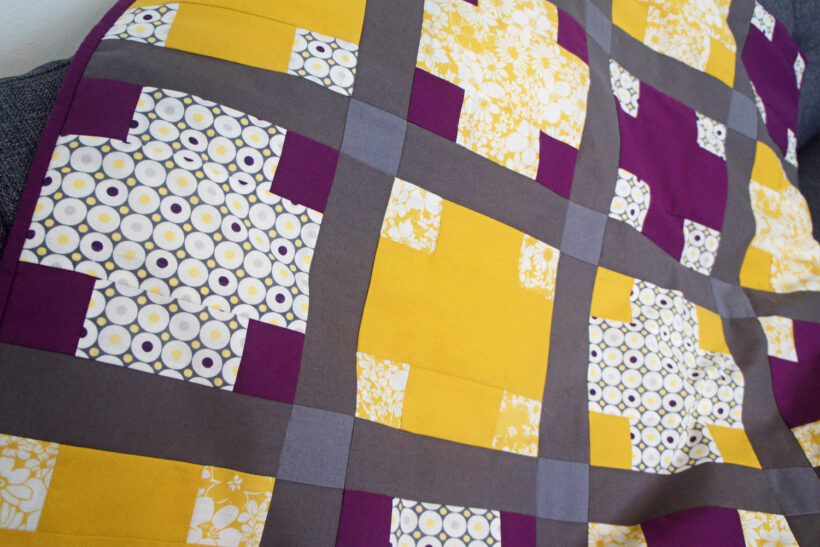 Lilla og gult patchwork babytæppe med krydser