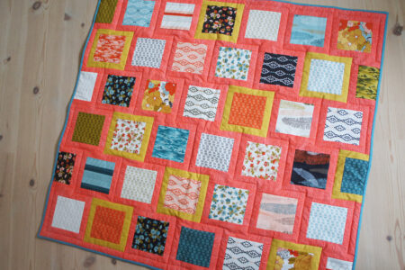 Farverigt patchworktæppe af charm pack