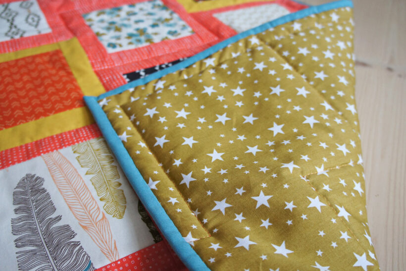 Farverigt patchworktæppe af charm pack